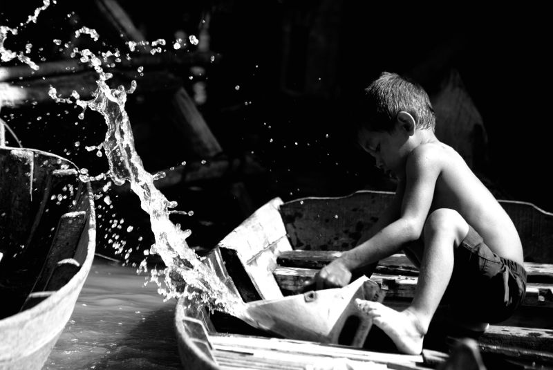 Kid scooping water off a boat - Edwin Lee - December 8 2008 – Licensed under CC BY-SA 2.0.